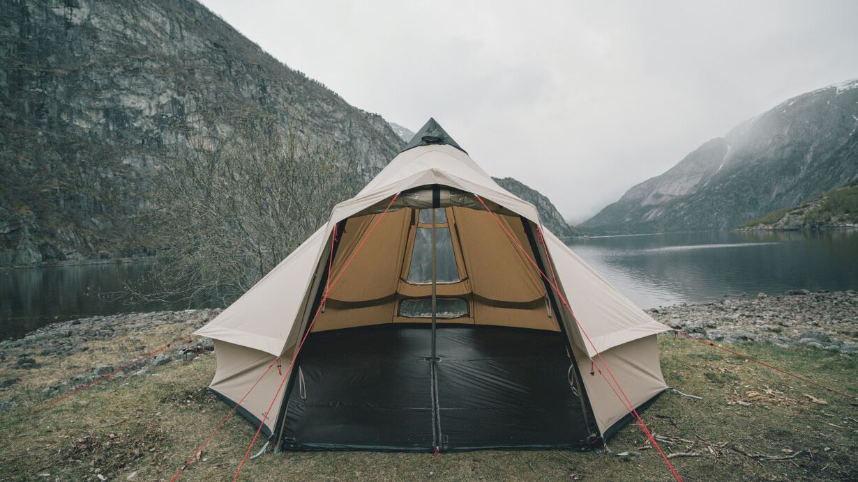 The Robens Settler Sky tent pitched by a lake in the mountains.